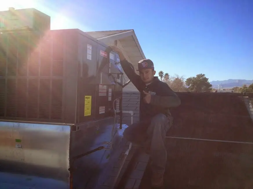 HVAC technician performing AC Tune-Up on a rooftop unit in O'Hara